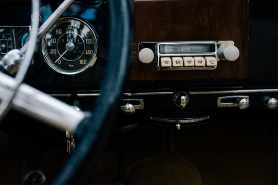 Fragment of metal steering wheel and dashboard of old classical automobile