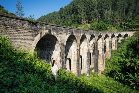 Young woman enjoying landscape of ancient bridge