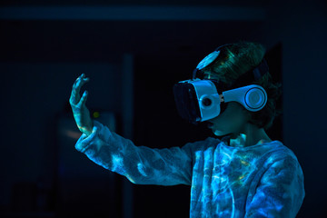 Child wearing virtual glasses at home with colored light effects