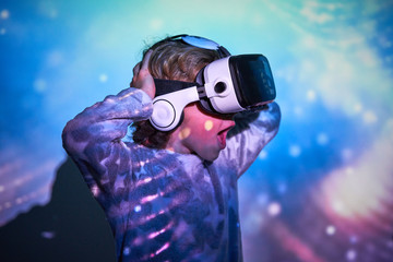 Child wearing virtual glasses at home with colored light effects