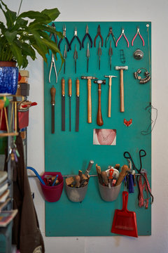 Green board with different tools arranged and hung