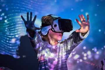 Child wearing virtual glasses at home with colored light effects