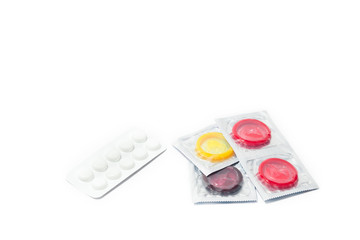 woman's hands with birth control pills and condom