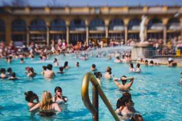 Budapest Spa Szechenyi Thermal Bath spa swimming pool with blue sky in summer day with a crowd of people