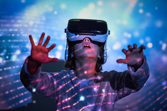 Child wearing virtual glasses at home with colored light effects