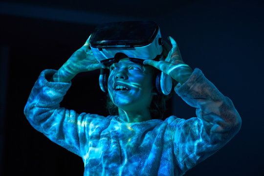 Child wearing virtual glasses at home with colored light effects