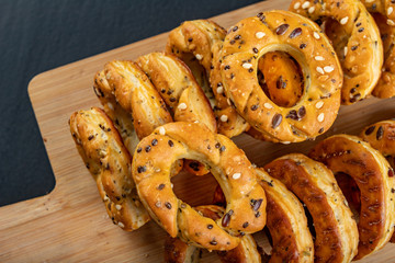 Crackers sprinkled with salt on a wooden board. Salty snack for an evening party.