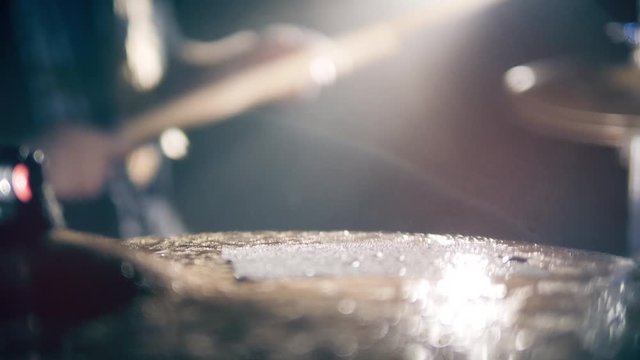 Surface of a wet drum cymbal while being played in a close up