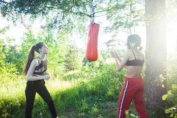 two diverse nations girls fighting boxing outside in green park, sport summer people concept