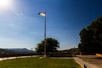 Hungarian flag back lit blue sky.