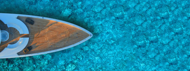 Fototapeta na wymiar Aerial drone ultra wide photo of mega yacht nose docked in tropical exotic island bay with turquoise clear sea