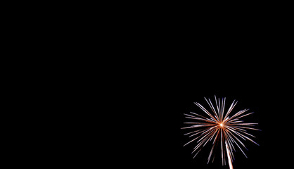 Small white starburst firework in lower right hand corner with black background