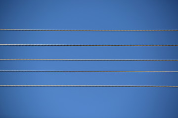 Horizontal wires / cables / lines against clear blue sky