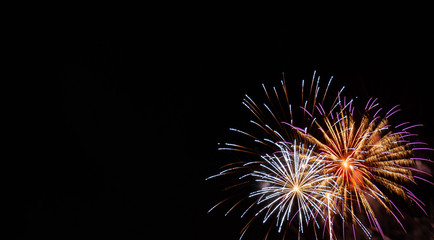 Fototapeta premium White and gold starburst fireworks with pink highlights with a black background