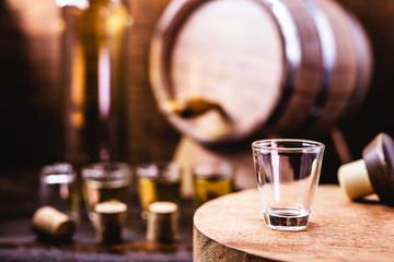 Glass of golden rum, with bottle. Bottle pouring alcohol into a small glass. Brazilian export type drink. Brazilian product for export, distilled drink known as brandy or pinga. Day of cachaça.