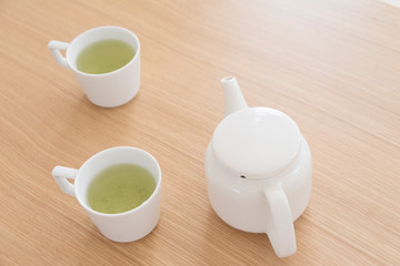 白い２つのマグカップと緑茶
