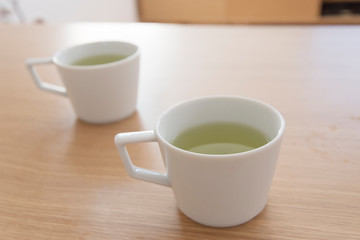 白い２つのマグカップと緑茶