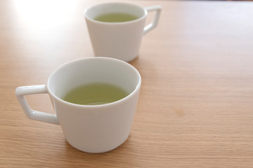 白い２つのマグカップと緑茶