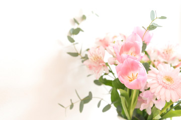 白背景　ピンクの花束　花　ピンク　アップ　部屋　壁　白壁　室内　屋内　自然光　チューリップ　ガーベラ　ユーカリ　装飾　素材　背景素材　グラフィック素材　春　季節　華やか　かわいい　優しい