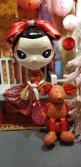 Closeup of lovely doll and red rat decoration.