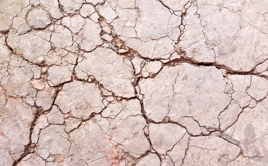 Broken soil or close-up damaged  ground. Photo of land in the desert. Cracked soil crust. Hard shadows and  dried soil from above. Royalty free stock images.