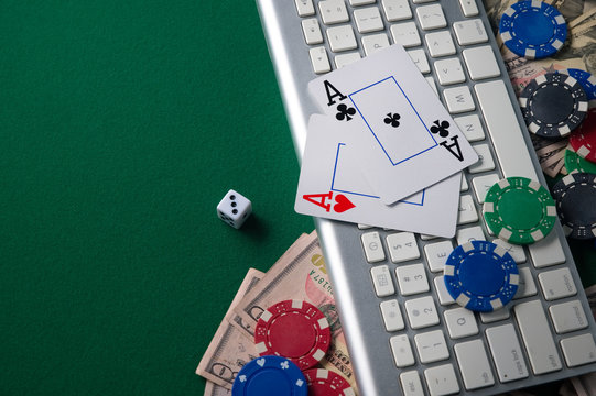 Flat lay. Poker online, casino, online gaming business. Chips, money cards and pc. Background for online gaming business. On a green gaming table with space for design or advertising.