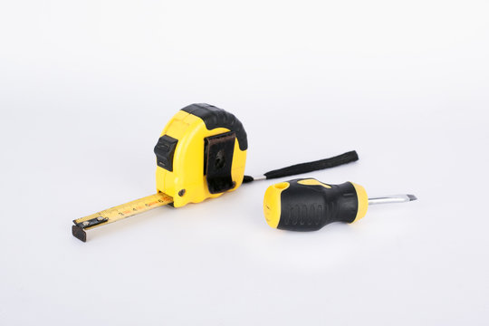 construction tape measure meter and screwdriver on a white background. repair preparation concept. building 