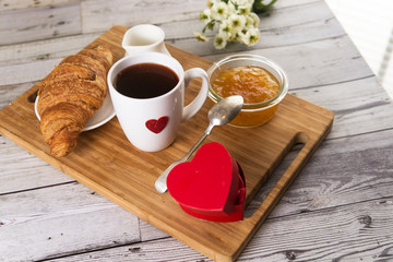 coffee and croissant with gifts in heart