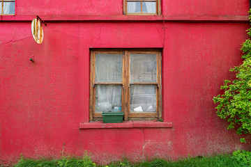 Fototapeta na wymiar Wooden windows on old red wall
