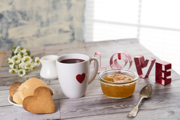 heart shaped cup of coffee and cookies