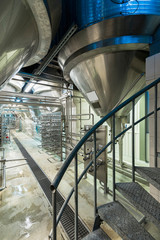 Close Up Of Modern Beer Factory. Rows of steel tanks for beer fermentation and maturation. (high iso image)