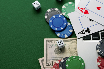 Gaming onlan business, online casino or casino. Green gaming table, laptop, money and chips. Game concept for design.