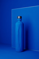 blue bottle on a blue background, art design,monochrome poster, vertical image, trend color phantom blue.