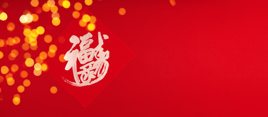 Chinese lunar New Year traditional Blessing for luck and happiness on the red background with festive holilday bokeh. Celebration concept, wide screen banner format with place for text