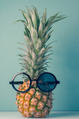 Fashion hipster pineapple.Tropical fruit with sunglasses.Creative art concept in a minimalist style.Agua Menthe color trend background.