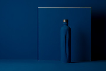 blue bottle on a blue background, art design, monochrome poster, horizontal image, trend color blue. - obrazy, fototapety, plakaty