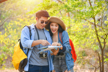 Young asian couple traveling together in park,hiking outdoors in forest. Active young asian man and woman hiker .