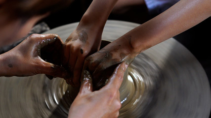Potters hands are creating a jar or vase of earthenware on wheel