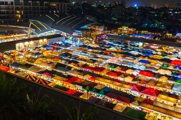 Top view of Train Night Market Ratchada (Talad Rot Fai). market with plenty of shops with colorful canvas roofs at night in Bangkok, Thailand