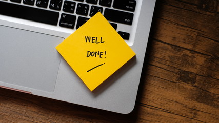 'Well Done' message concept written post it on laptop keyboard