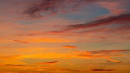 Fototapeta premium Evening sunset sky with bright rays of the sun and beautiful colorful clouds