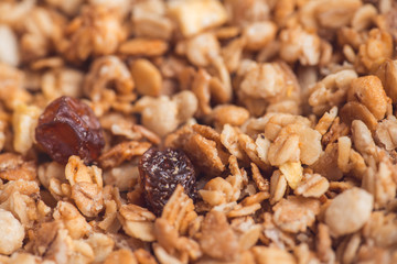 Useful and tasty muesli with nuts, rasins and flakes. Selective focus macro shot with very shallow depth of field. Healthy and vegetarian lifestyle