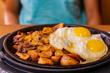 Close up shot of two fried sunny egg and potatos