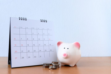 Calendar With Days and piggybank on wood table