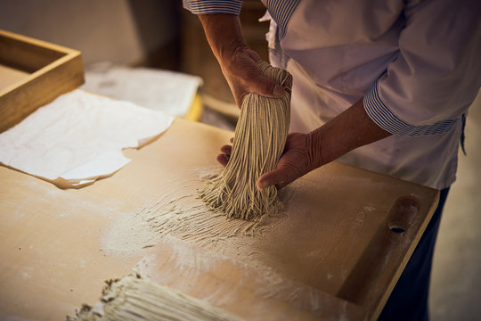 手打ち蕎麦の打ち粉を払う