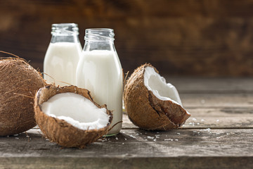 Coconut kefir in glass bottle on wooden table. Vegan non dairy healthy or fermented drink. Healthy eating concept