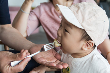 Little asian boy eating bread