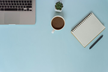 Top view workspace mockup on blue background with notebook and coffee.