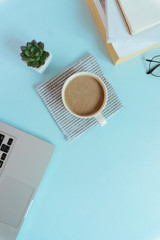Top view workspace mockup on blue background with notebook and book.