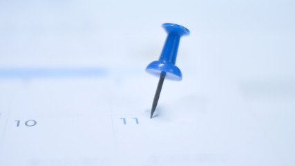Close up  blue pin marking on calendar planning concept.